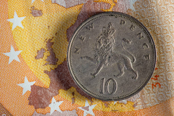 валютные деньги макро: 10 пенс монета на 50 евро банкноты - pound symbol flash стоковые фото и изображения