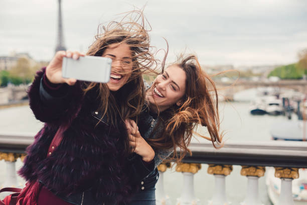 Girls enjoying vacation in Paris Young women in Paris taking selfie against the Seine river seine river photos stock pictures, royalty-free photos & images