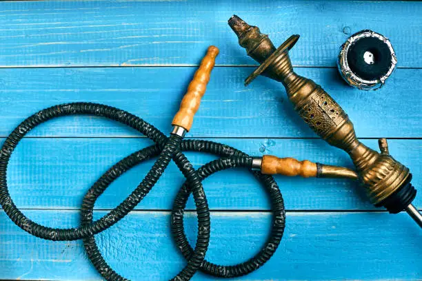 Photo of Parts of the hookah on blue wooden background. Hookah accessorie