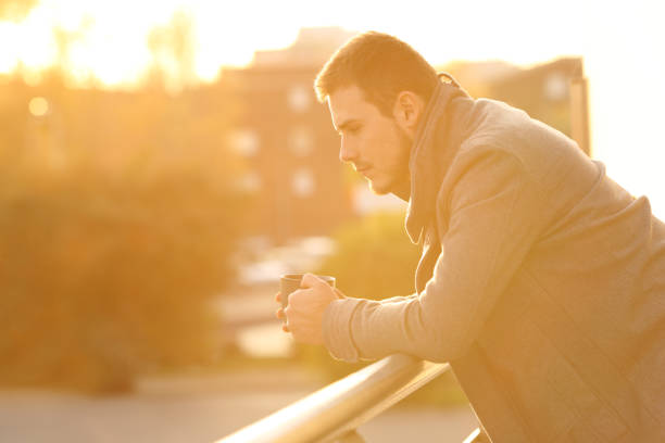 istock Sad man looking down in a balcony in winter 903738632