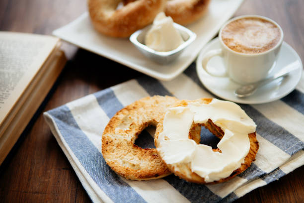 Montreal style bagels on a plate with cream cheese and coffee Montreal style bagels on a plate with cream cheese and coffee cream cheese photos stock pictures, royalty-free photos & images