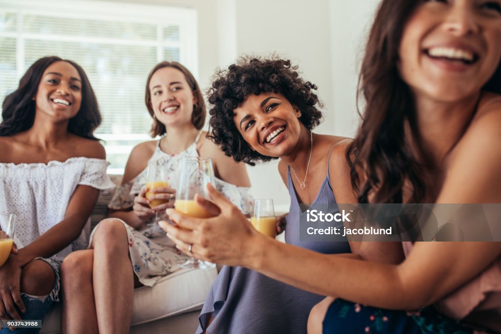 Group of multiracial friends at a party Group of multiracial friends at a party and smiling. Women friends having a party at home and looking away. Women Stock Photo