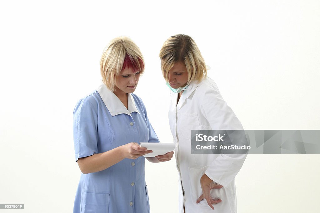 Reviewing pacient's files Doctor and nurse reviewing pacient's files Doctor Stock Photo