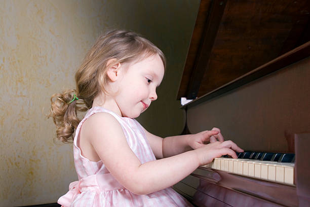 Girl playing piano  girl playing piano stock pictures, royalty-free photos & images