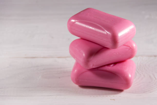 istock Stack of three pink soap on white wooden background 903758536