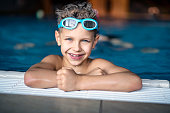 Portrait of strong little boy at the swimming pool