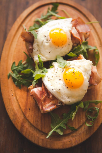 istock Fried eggs sunny side up on baguette, ham and arugula 903764392