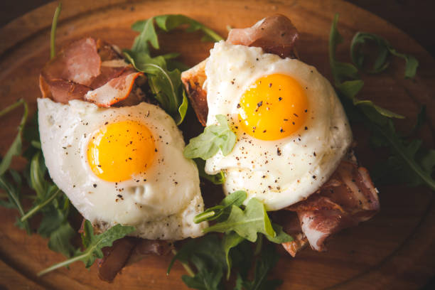 istock Fried eggs sunny side up on baguette, ham and arugula 903764742