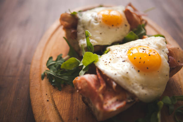 istock Fried eggs sunny side up on baguette, ham and arugula 903764878