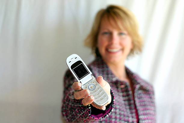 Woman offering cell-phone stock photo