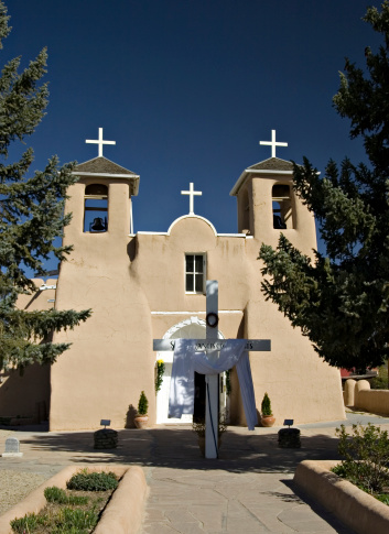 The San Francisco de Assisi (Saint Francis of Assisi) Catholic Mission Church in Ranchos De Taos, New Mexico is a Spanish colonial church completed in 1816.  This image was taken the Monday after Easter, so the cross is still draped in white. 