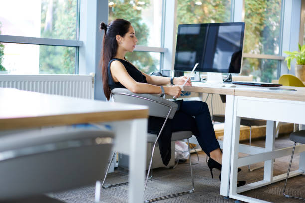 istock Confident female editor dressed in trendy elegant formal wear proofreading financial article for publication, businesswoman checking report of company sales income sitting near computer mock up screen 903770446
