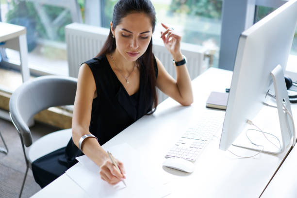 istock Creative prosperous editor of online issue noting best ideas for article publication browsing information on computer using wireless connection, administrative manager of company making schedule 903770630