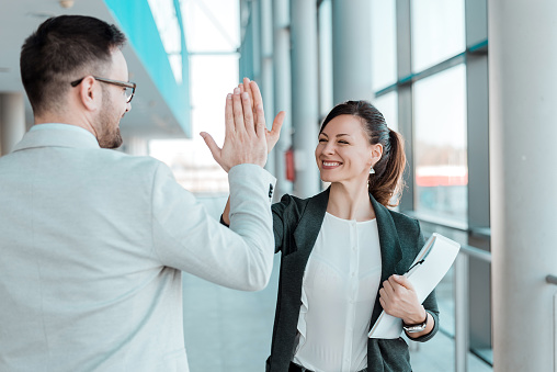 Two excited business colleagues team give high five.