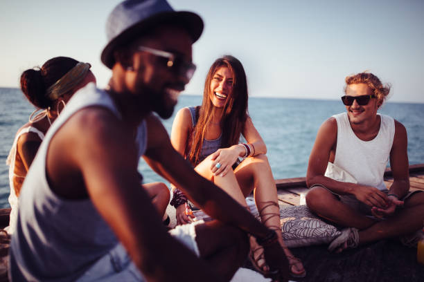 istock Multi-ethnic hipster couples relaxing and having fun multi-racial on jetty 903785116