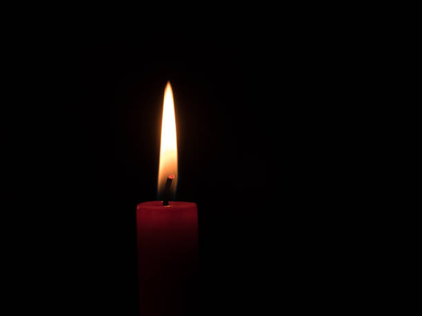 istock flame of a candlelight in the darkness 903792076