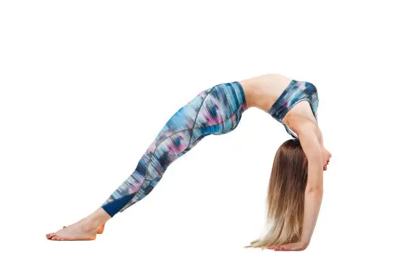 young beautiful woman in color-blue top practicing yoga, stretching in Urdhva Dhanurasana exercise, Bridge pose, working out isolated over white studio background