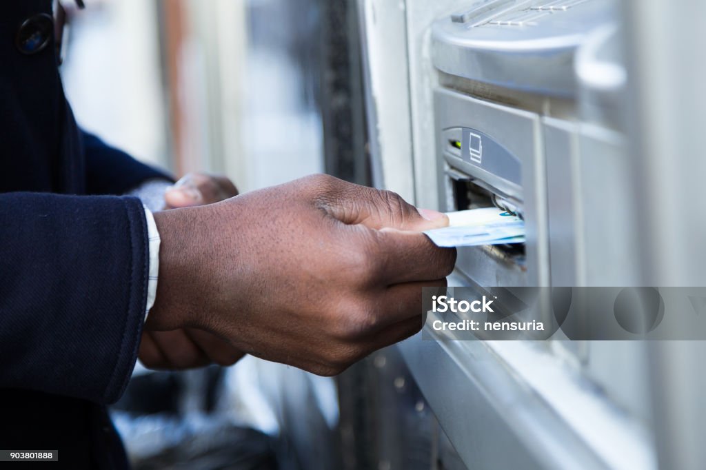 Close up of man taking cash from ATM with credit card. ATM Stock Photo