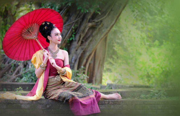 istock Young Woman With Red Umbrella Sitting On Retaining Wall 903802932