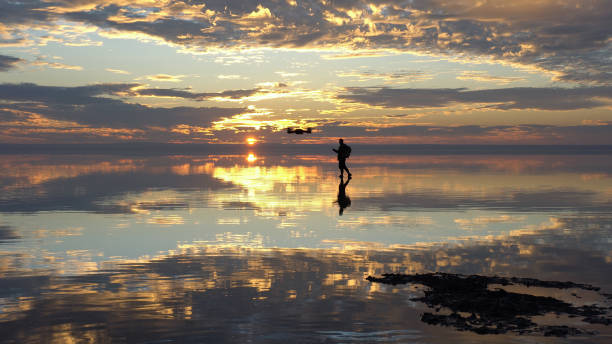 istock Travelist having fun with Drone on salt lake at sunset 903807436