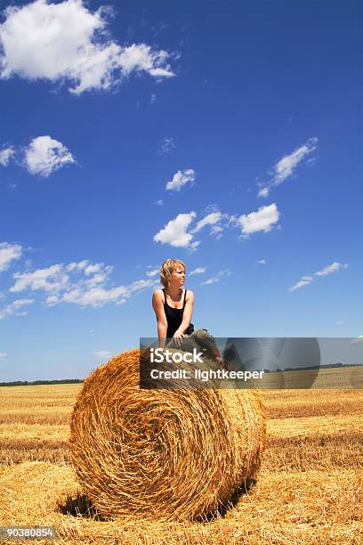 Foto de Mulher Sentada Em Um Feno Bale e mais fotos de stock de Adulto - Adulto, Atividade Recreativa, Azul