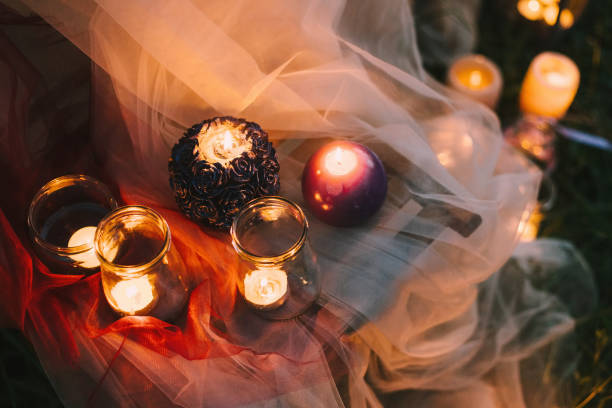 istock Night fine art rustic outdoor wedding details summer or spring ceremony with decor burning lowlight candles standing on table covered with veil soft cloth tulle pastel tones and on the grass 903814338