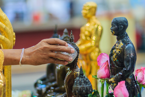 Close up hand of Thai people while bathing rite to buddha images in Songkran festival on the April 13 annual ritual every year. Buddhist is bathing a Buddha statue to gain merit during Thai New Year.