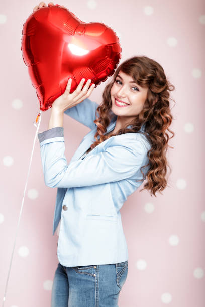 istock woman with heart shaped air balloons 903818970