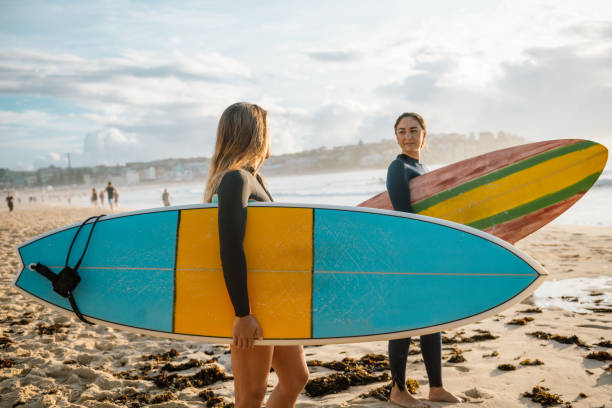 istock Beach, summer, waves and surfboards - what else two girls may need 903819726