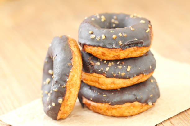 istock Chocolate doughnuts with chocolate glaze pouring over 903829904