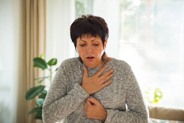 Sick mature woman with sore throat stock photo
