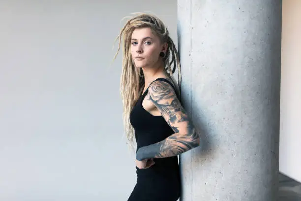Portrait of tattooed and pierced young women with blond dreadlocks