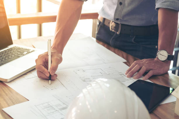 istock Image of engineer or architectural project, Close up of engineer's hand drawing plan on BluePrint with Engineering tools on workplace 903845446