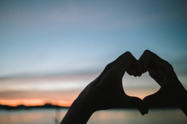 istock Silhouette of hands shape heart with twilight evening sky. 903846588