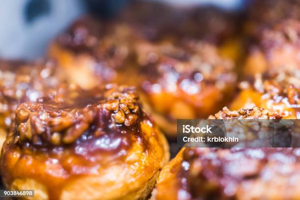 Macro Closeup Display Of Chocolate Drizzled Pecan Nut Sticky Buns Danish Pastries Caramelized In Bakery For Breakfast Stock Photo - Download Image Now