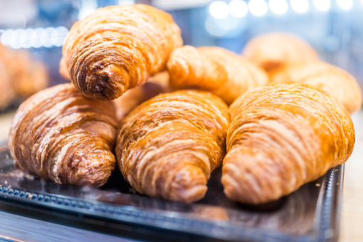 Macro closeup display of plain butter croissant crescent pastries in bakery for breakfast