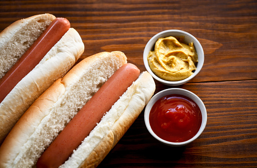hot dog with mustard and ketchup on a wooden table -fast food-snack-sausage