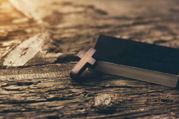 istock Cross and  book on wooden table 903858144