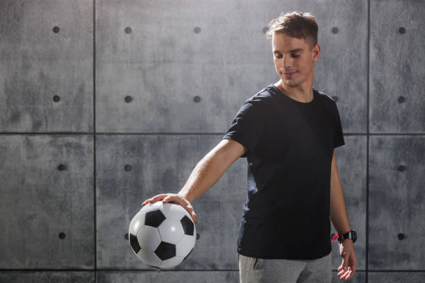 istock Young man holding soccer ball in hand 903862490