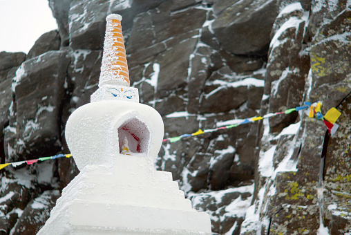 KACHKANAR, RUSSIA - JANUARY 09, 2018: Buddhist stupa in the monastery of Shad Tchup Ling - the only Buddhist monastery in the Ural Mountains - against the background of a blurred snow-covered rock