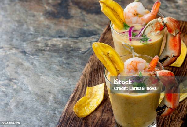 Peruvian Seviche Leche De Tigre Tiger Milk Raw Fish Cocktail Ceviche With Lime Grinder Chili And Cilantro Traditional Peruvian Food Decorated With Crabs Srimps And Banana Chips Stock Photo - Download Image Now