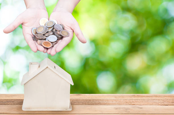 istock hand holding coins house bank save money 903866802