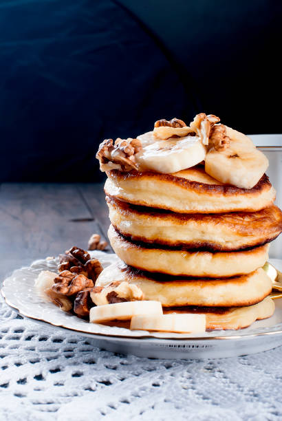 istock Pancakes with banana, nuts ,honey and cup coffee on dark background 903873084