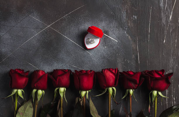 istock Valentines day marry me wedding engagement ring in box with red rose gift 903877154
