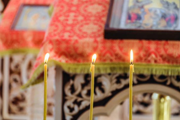 istock Three burning candles on a blurred background of the pulpit with an icon for liturgy, prayers and sermons. Russian Orthodox Church. Selective focus. 903884436