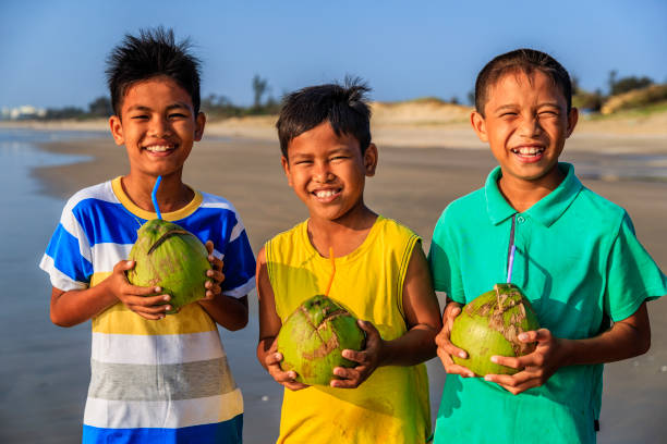 istock Vietnamese children holding coconuts on the beach, Vietnam 903892814