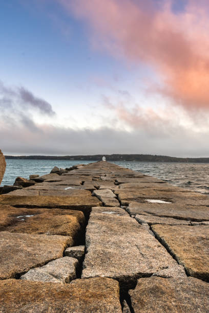 Low Angle of Long Walkway to Lighthouse Low Angle of Long Walkway to Lighthouse in Rockland groyne stock pictures, royalty-free photos & images