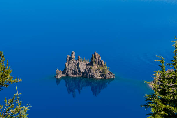 istock Phantom Ship Rock Through The Trees of Crater Lake 903900410