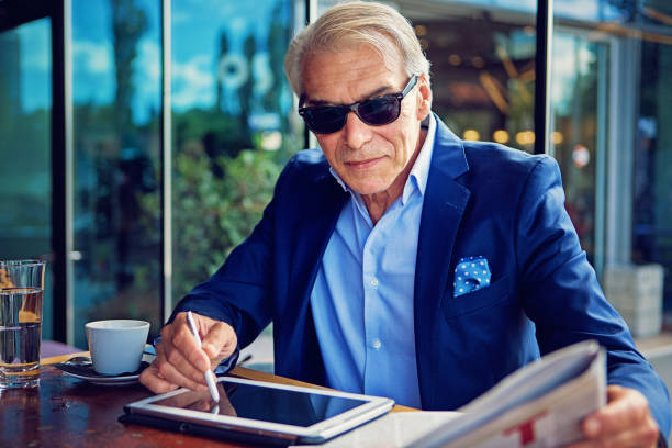 istock Businessman is reading newspaper and writing in his digital tablet 903903594