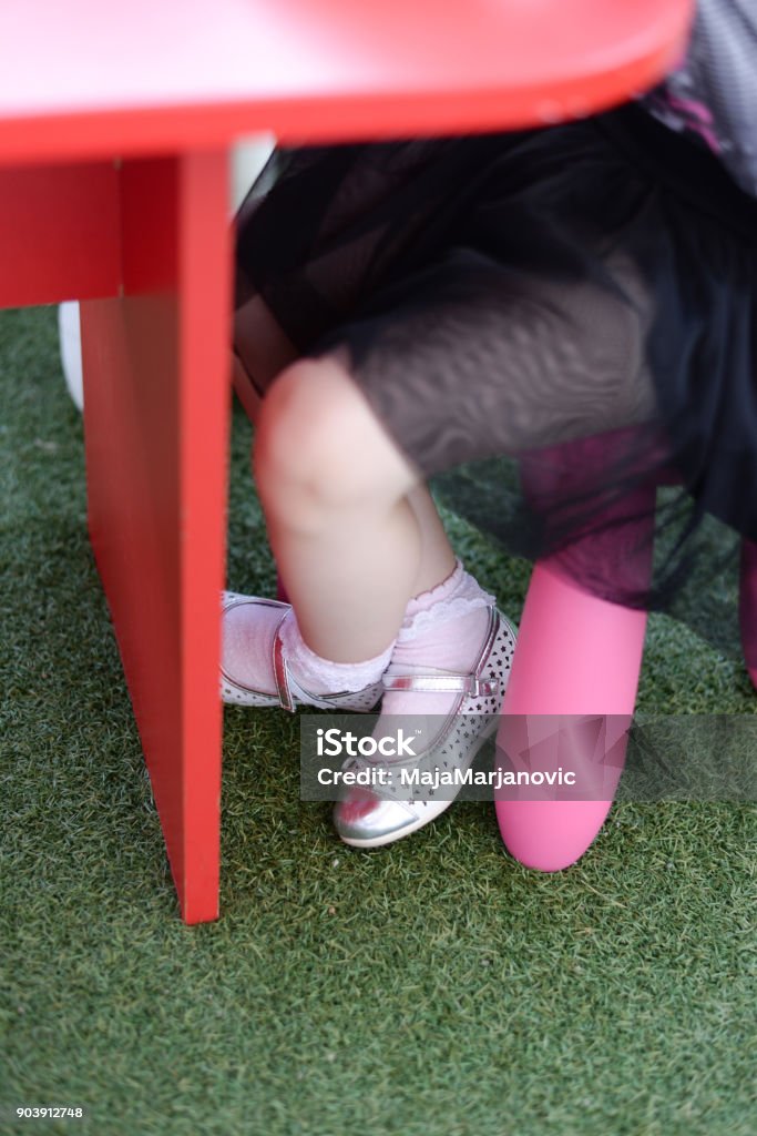 Mädchen sitzen auf Kunststoff-Stuhl unter Schreibtisch. - Lizenzfrei Baby Stock-Foto